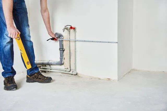 TK Plumbing technician measuring pipes for sewer line repair in Sarasota