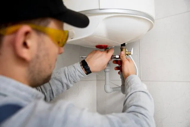 TK Plumbing technician installing tankless water heater in Sarasota home